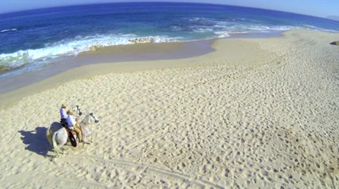 2 men on white horses running on the beach Video stock 32818893
