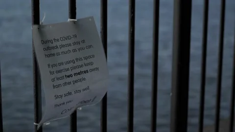 2 meter social distancing health warning sign attached to a metal railing Stock Footage 131521069