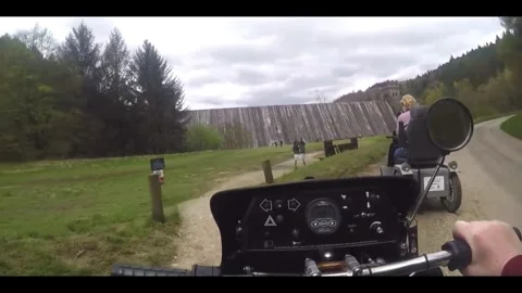 2 Mobility Scooters riding down to Derwent Dam in the Peak District Stock Footage 284560331