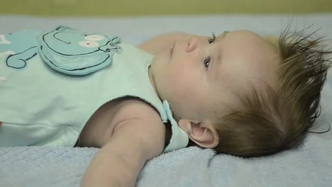 2 months baby looking at the camera, smiling, lying on his back. Stock Footage 114968143
