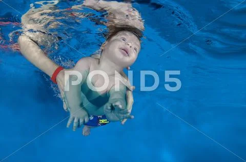 2 months infant boy learning to swim underwater in waterbaby class in the poo Stock Photos
