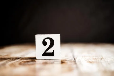 2 - Number 2 - Number Two - White block with number on wooden table and dark  Foto stock