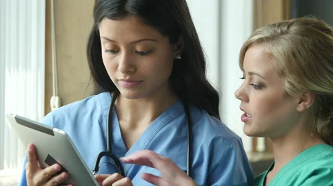 2 Nurses in consultation and looking at information on ipad Stock Footage 53125786
