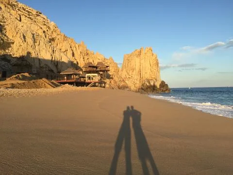 2 people on a beach with shadow during sunset Stock Photos