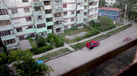 2 people having a look at the old red car engine in a La Habana neighborhood Video stock 55213483