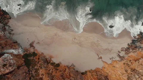 2 people laying down in private cove on a beach Drone Stock Footage 241362467