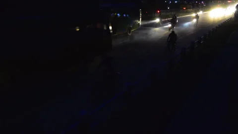 2 people riding bicycle alongside a Huge traffic full of vehicles in a highway Stock Footage 248733574
