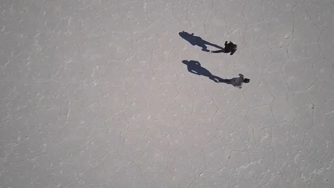 2 people run in slow motion on the salt flats in the Salar de Uyuni Stock Footage 83404756