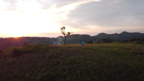 2 people running on a hill at sunset Stock Footage 240318076