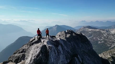2 People standing on mountain top, Drone shot, Forest fire smoke Stock Footage 289575661