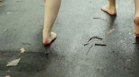 2 persons walking barefoot on wet road in autumn. Legs' close-up Stock Footage 46292977