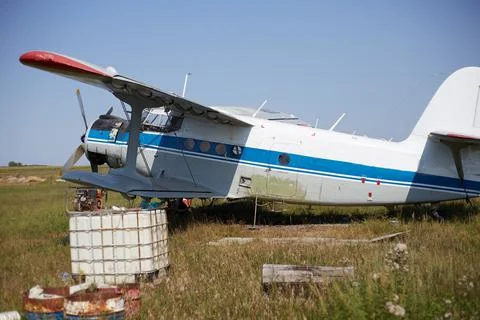 An An-2 plane is on the ground, an old plane in the neighborhood lies all sor Stock Photos