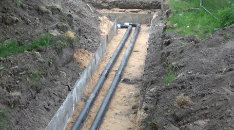 2 plastic water heating pipes in a ditch with a turn Stockbeeldmateriaal 55865254
