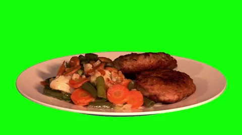 2 pork chops and stewed vegetables on plate Stock Footage 47575501