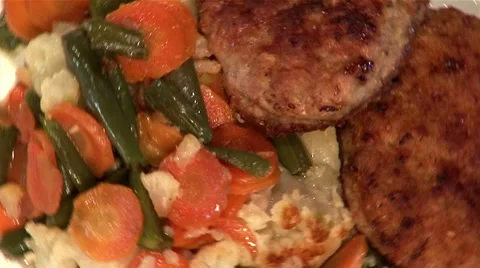 2 pork chops and stewed vegetables on plate, top shot, close-up Stock Footage 47576074