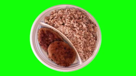 2 pork chops with buckwheat on throwaway plate, top shot Stock Footage 47548728