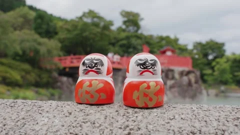 2 red Daruma dolls rest on stone platform at Katsuoji Temple in Osaka Stock Footage 344283157