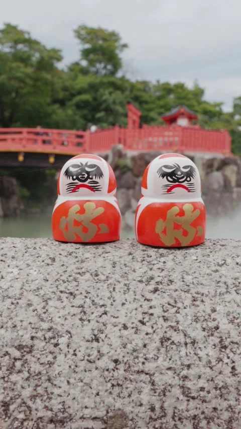 2 red Daruma dolls rest on stone platform at Katsuoji Temple in Osaka Stock Footage 345740963