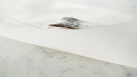 2 Salmon fillets opened from grease-proof paper on marble. Stock Footage 92144143