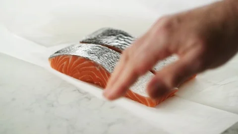 2 Salmon fillets opened from grease-proof paper on marble. Stock Footage 92144145