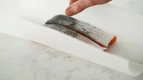 2 Salmon fillets opened from grease-proof paper on marble. Stock Footage 92144444