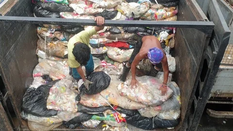 2 sanitation workers piling garbage bags on top of garbage truck. Video stock 113728424