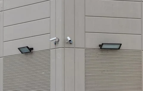 2 security cameras on the side of a building Stock Photos