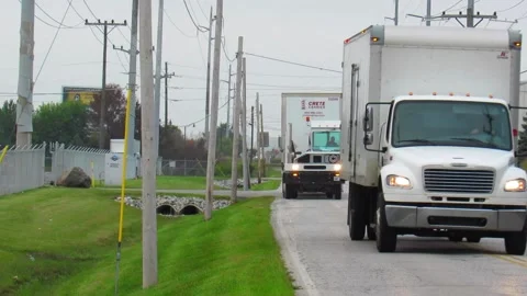 2 semis driving down road between 2 factories Stock Footage 139121095
