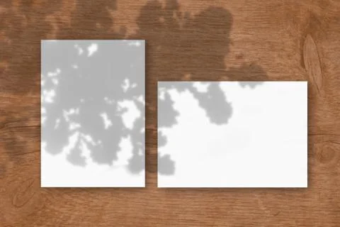 2 sheets of white textured paper against a wooden table background. Mockup ov Stock Illustration