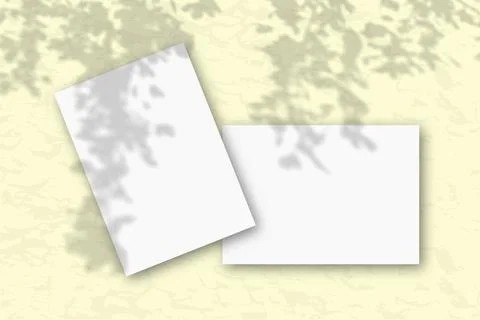 2 sheets of white textured paper against a yellow wall. Mockup with an overlay Stock Illustration