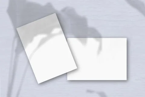 2 sheets of white textured paper against a grey wall. Mockup overlay with the Stock Photos