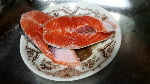 2 slices of salmon in a patterned melamine plate Stock Footage 145496298
