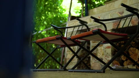 2 small chairs into a courtyard along with a beautiful green background Video stock 158018047