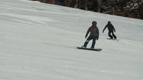 2 snowboarders sharing a run down a groomed ski resort in Hakuba Japan Stock Footage 166373162