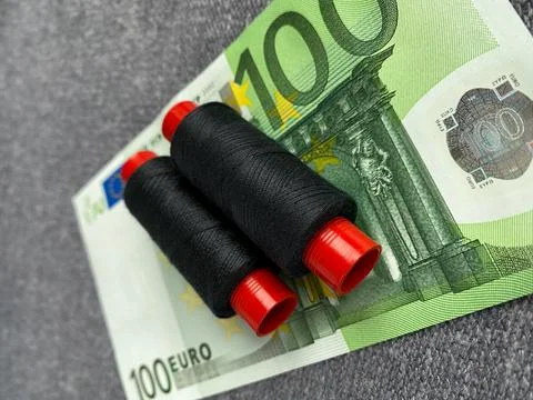 2 spools of threads are on the 100 euro banknote. The background, fabric Stockfoto's