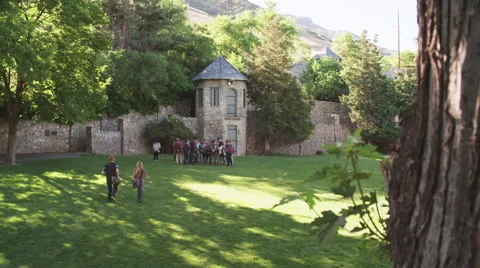 2 Students Run to Join Group of Students at Castle Tower Stock Footage 62651505
