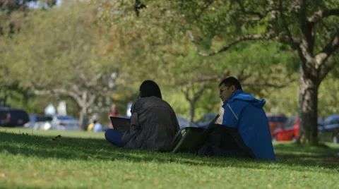 2 Students sit and work outdoors at University campus Stock Footage 44267205