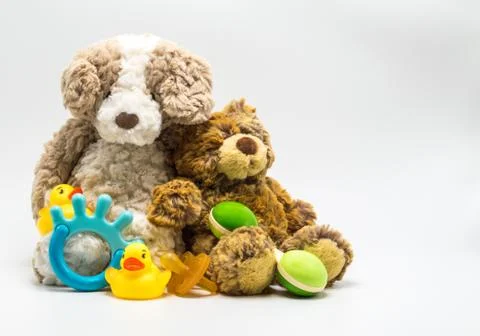 2 teddy bears leaning on each other surrounded by baby gear Stock Photos
