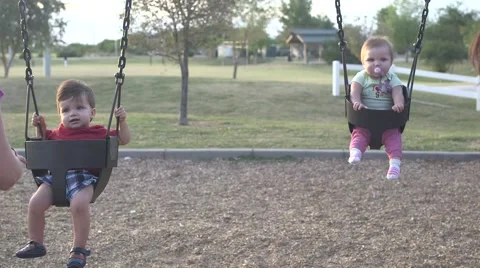 2 toddlers on swings Stock Footage 44058111