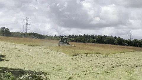 2 Tractors cutting down grass in a large field in Kent Stock Footage 204871060