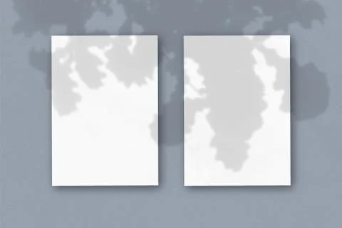 2 vertical sheets of textured white paper on soft gray table background. Mock Stock Illustration