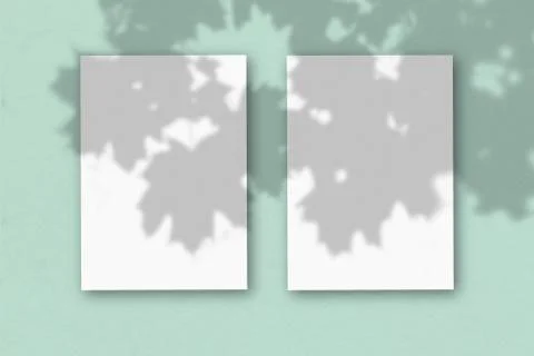 2 vertical sheets of textured white paper on light green table background. Mo Stock Illustration