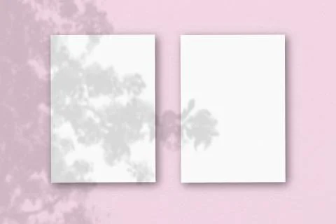 2 vertical sheets of textured white paper on pink table background. Mockup ov Stock Illustration