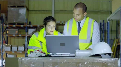 2 warehouse workers in high visibility clothing discuss their business Stock Footage 13696593