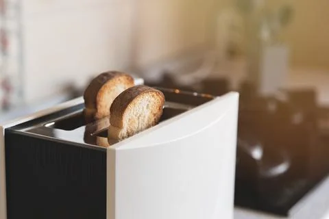 2 white toasted slices of bread in a white toaster in home kitchen, selective Stock Photos