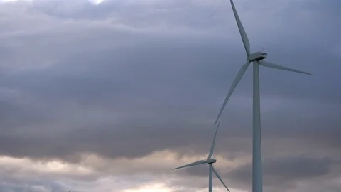 2 windmill turbines close-up against the backdrop of thunderstorm clouds. Video stock 105680728