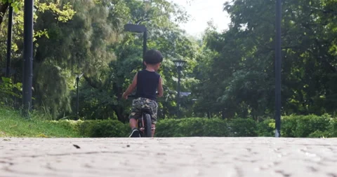 2 year asian boy playing balance bike on pathway in park sport recreation Stock Footage 138728418