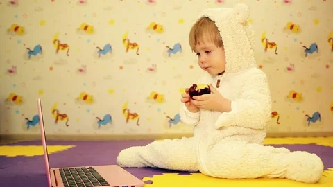 2 year old boy eats apple and wathces laptop Stock Footage 144468466
