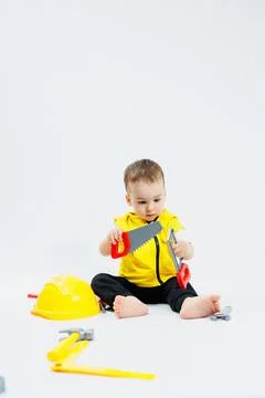 A 2-year-old boy plays with plastic construction tools. Children's plastic .. Foto stock