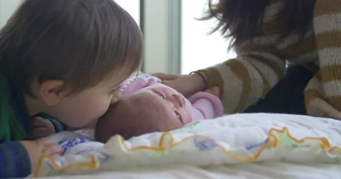 2 year old brother kisses his new born baby sister 스톡 동영상 58757853